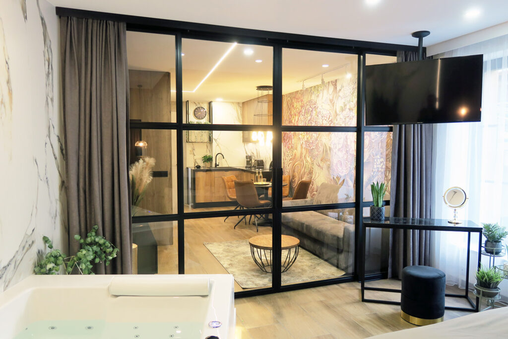 Glass doors-metal and glass sliding doors. Our metal doors can be integrated into fixed glass partitions or installed independently. They allow dividing space, e.g. between living rooms, bedrooms and office areas. This unit consists of two fixed side parts and two sliding parts.